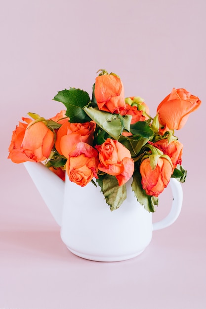 Photo wither orange rose in enameled teapot