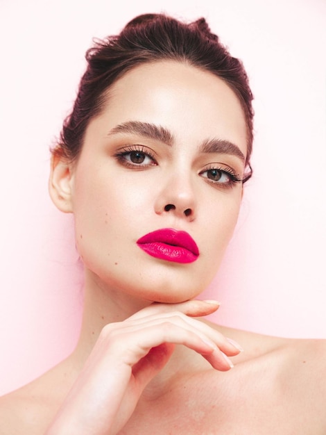 Photo without retouch photo for practise portrait young brunette woman with evening stylish makeup and perfect clean skin sexy model with hair in a bun posing in studio with pink bright natural lips