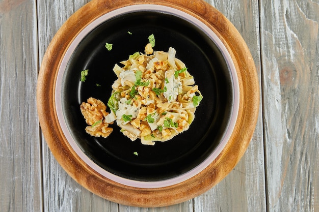 Witlofsalade met andijvie en roquefortsaus op een zwart bord