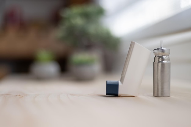 Witte astma-inhalator met patroon op houten tafel wazige achtergrond