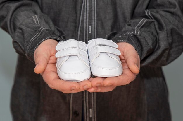 Witte babyschoentjes in vaders hand