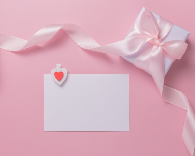 Witte blanco vel papier en geschenkdoos op een roze achtergrond. Valentijnsdag concept.