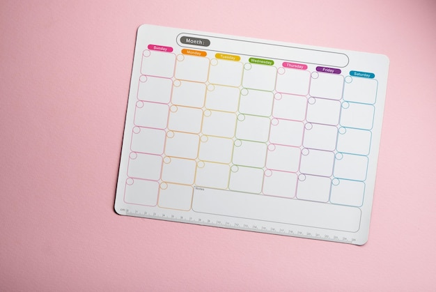 witte blanco wekelijkse planner tegen roze achtergrond