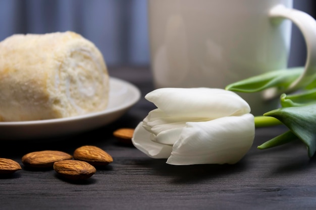 Foto witte bloem met koffie en biscuit met amandelen