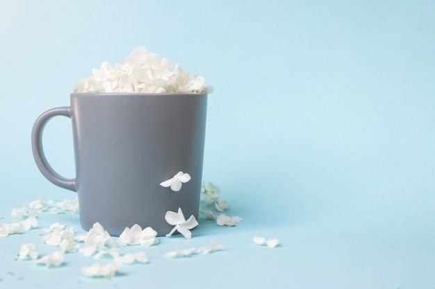 Witte bloemblaadjes in een kopje koffie in de ochtend.