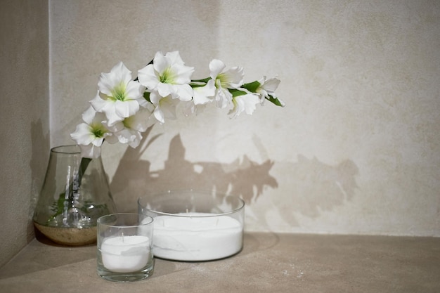 Witte bloemen in een transparante vaas en kaarsen de sfeer van ontspanning in het bad van de spa salon