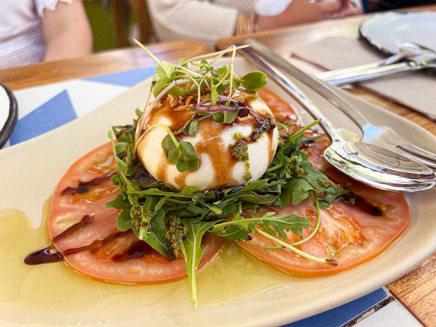 Witte bol zachte Italiaanse kaas mozzarella met verse bladeren en plakjes tomaat