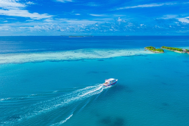 Witte boot in tropische lagune met eiland blauwe zee achtergrond. Buitensport, snorkelduikjacht