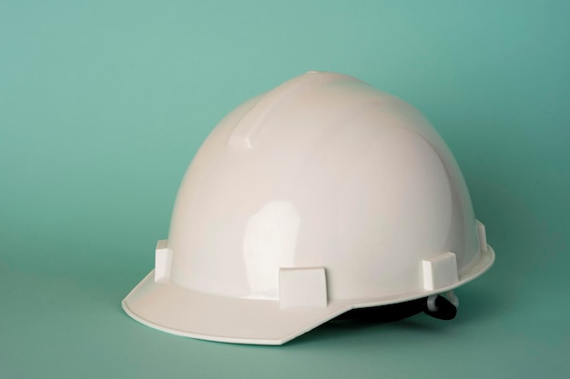 Witte bouw beschermende helm op een turkooizen achtergrond, veiligheid, arbeidsbescherming