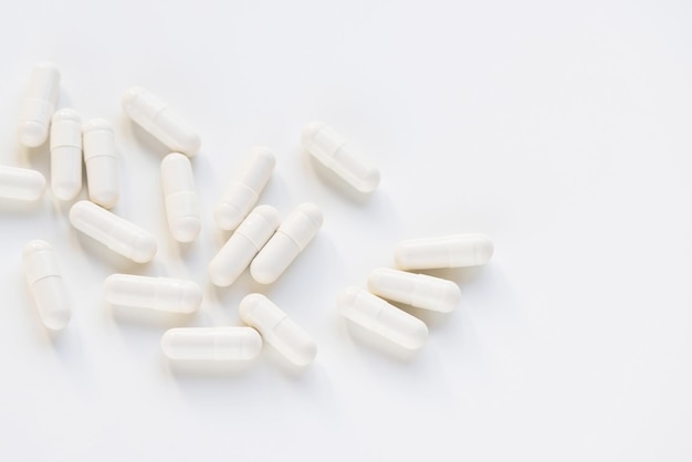 Witte capsule pillen op witte achtergrond supplement en geneeskunde concept close-up kopie ruimte