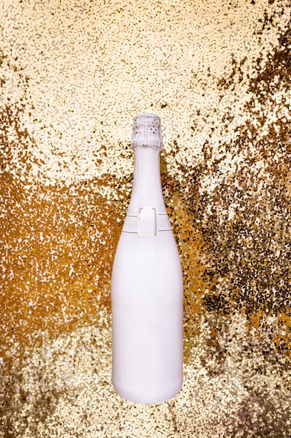 Foto witte champagnefles op gouden achtergrond plat lag bovenaanzicht trendy kerstconcept