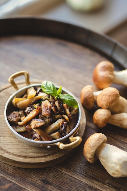 Witte champignons in een vintage koekenpan op een houten ondergrond.