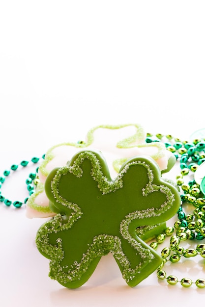 Foto witte chocoladekoekjes in de vorm van een klavertje vier voor st. patrics day.