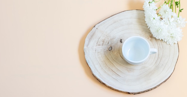 Witte chrysant tak en lege koffiekopje op het trendy houten bord