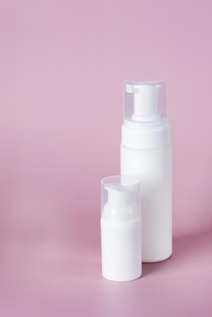 Foto witte cosmetische fles mockup op roze achtergrond minimalistisch product stilleven