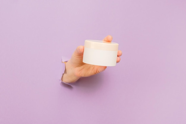 Witte cosmetische gezichts- of huidcrème pot in de hand Verpakking voor cosmetische schoonheidsproducten luxe make-up container spa