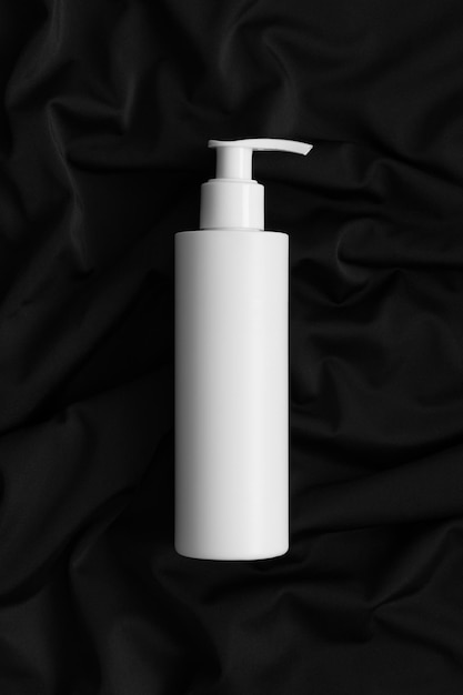 Witte cosmetische shampoo dispenser fles mockup op het zwarte textiel