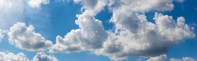 Witte cumuluswolken in de blauwe lucht op een zonnige dag