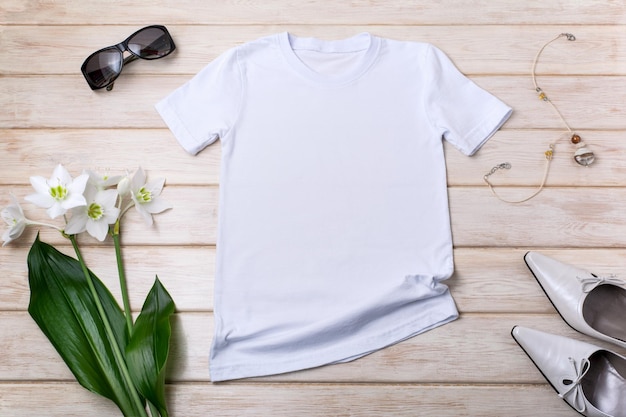 Witte dames katoenen tshirt mockup met lelie bloemen groene bladeren ketting hakken en zonnebril Design t shirt sjabloon tee print presentatie mock up