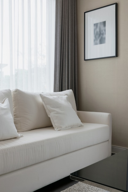 Witte decoratieve kussens op een informele sofa in de woonkamer