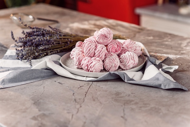 Witte dienblad met verse marshmallows op marmeren tafel met handdoek en lavendel.