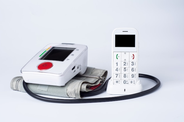 Witte elektronische tonometer met telefoon en tablets