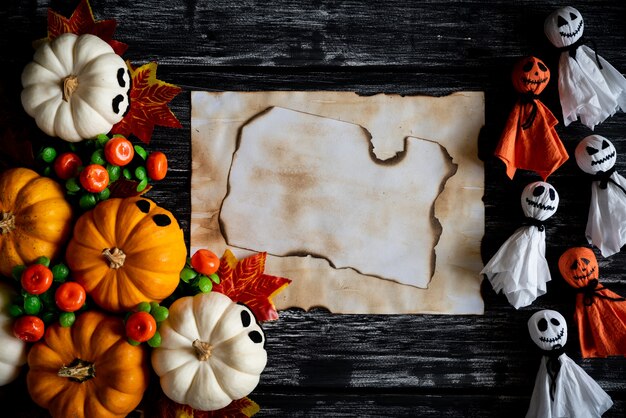 Witte en gele spookpompoenen met de Herfstbladeren en oud document op een zwarte houten backgro