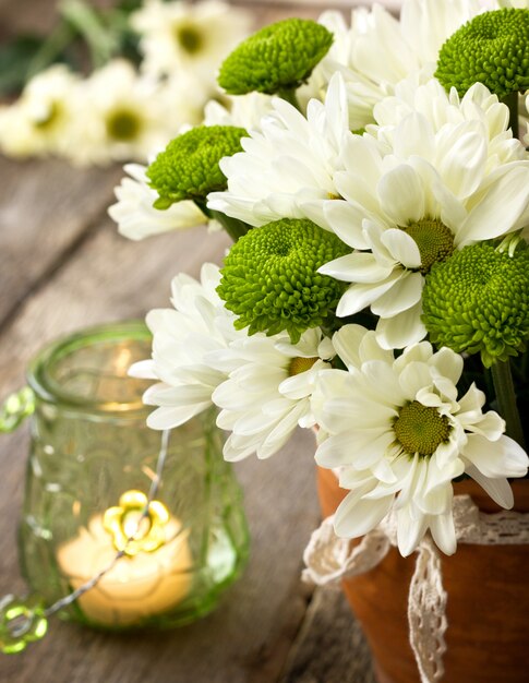 Witte en groene chrysanten op oude houten achtergrond