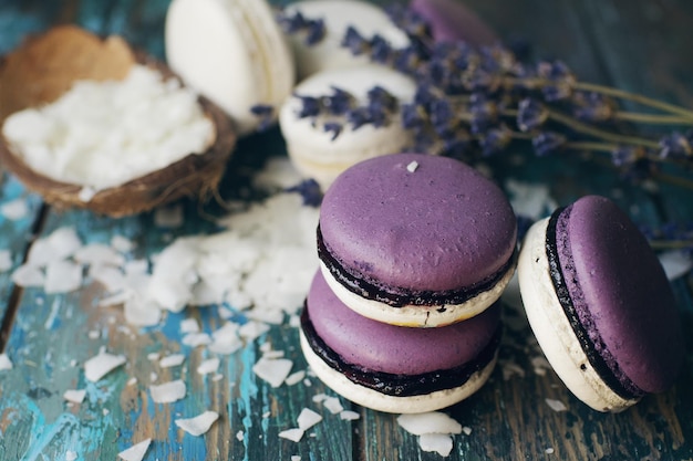 Witte en paarse macarons of bitterkoekjes versierd met droge lavendelbloemen en kokos