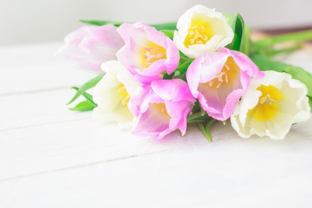 Witte en paarse tulpen op een witte houten achtergrond