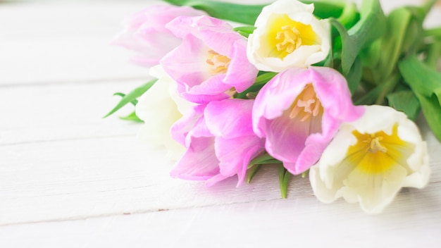 Witte en paarse tulpen op een witte houten achtergrond