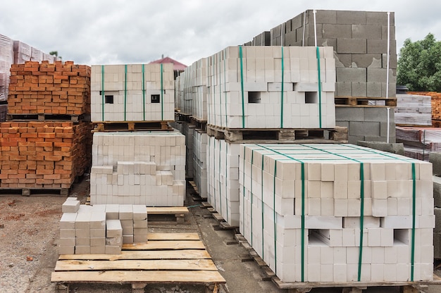 Witte en rode bakstenen gestapeld op pallets