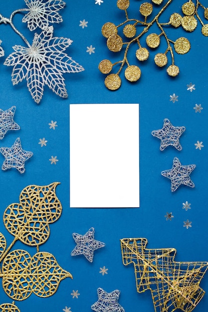 Witte en zilveren versieringen plat op een klassieke blauwe achtergrond met kopieerruimte. kerstachtergrond in kleur klassiek blauw met witte en zilveren ornamenten, kerstachtergrond met verlanglijstje