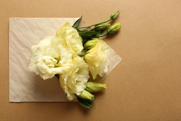 Witte eustoma in envelop op beige achtergrond