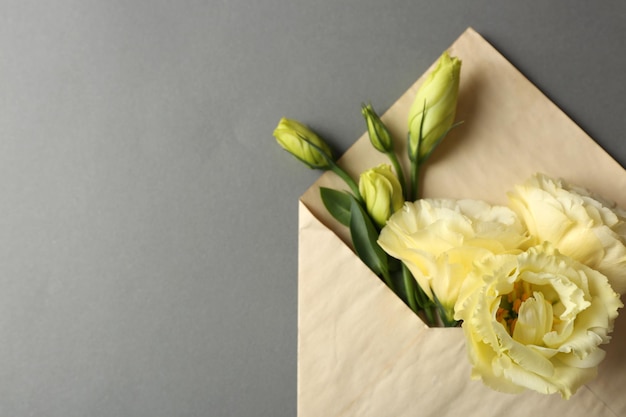 Witte eustoma in envelop op grijze achtergrond