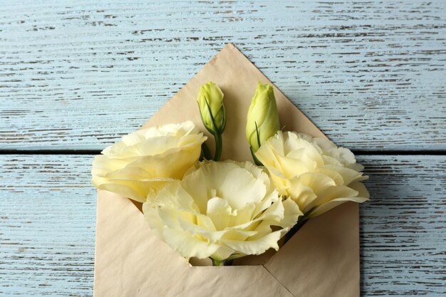 Witte eustoma in envelop op houten ondergrond