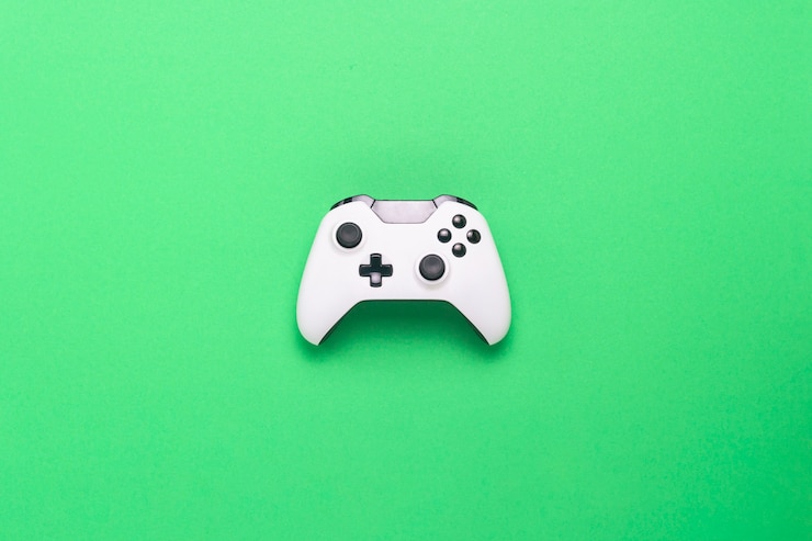 Witte gamepad op een groene achtergrond. Conceptspel op de console, computerspellen. Plat lag, bovenaanzicht.