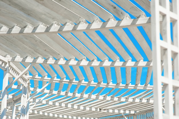 Witte gazebo in het park tegen blauwe hemel