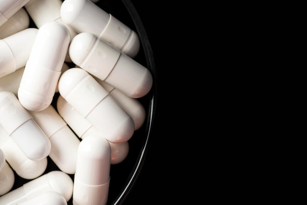 Witte geneeskunde Drug Capsules op zwarte achtergrond Macro close-up