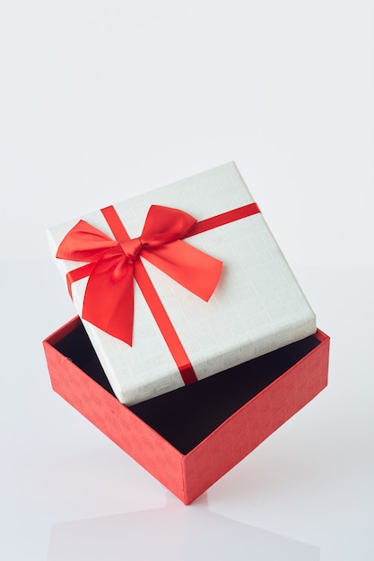 Witte geschenkdoos met rode strik op wit