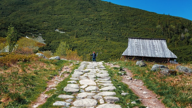 Witte gestenigde weg in verafgelegen bergvallei en fotograaf