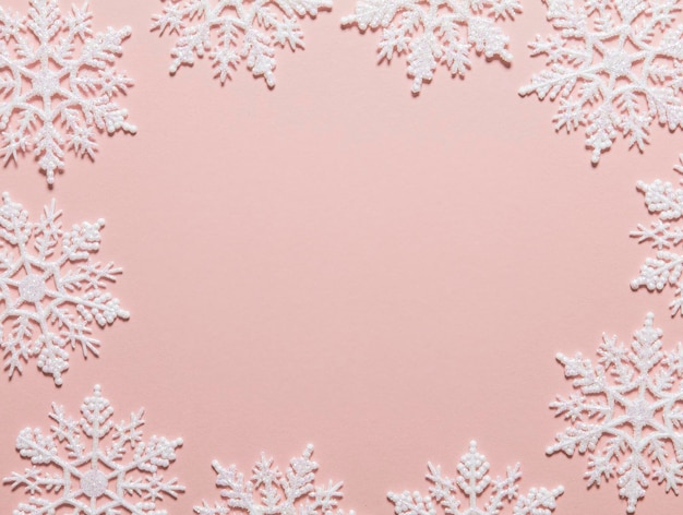 Witte glitter sneeuwvlok compositie op een pastelroze achtergrond