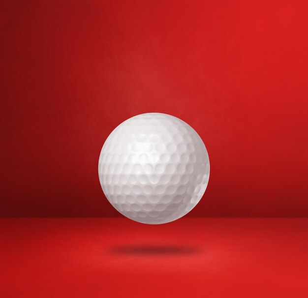 Witte golfbal geïsoleerd op een rode studio achtergrond. 3d illustratie