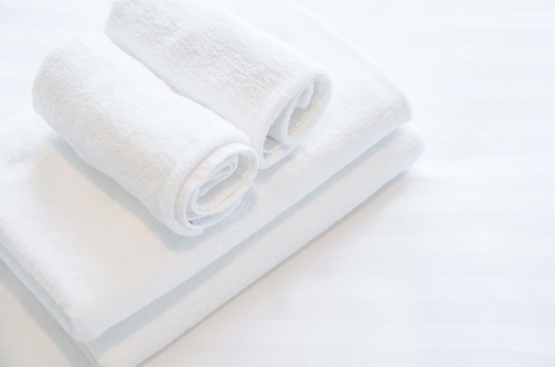 witte handdoek op witte bed in slaapkamer