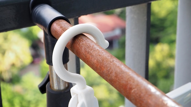 Witte hangers hangen op roestige kledingrails.