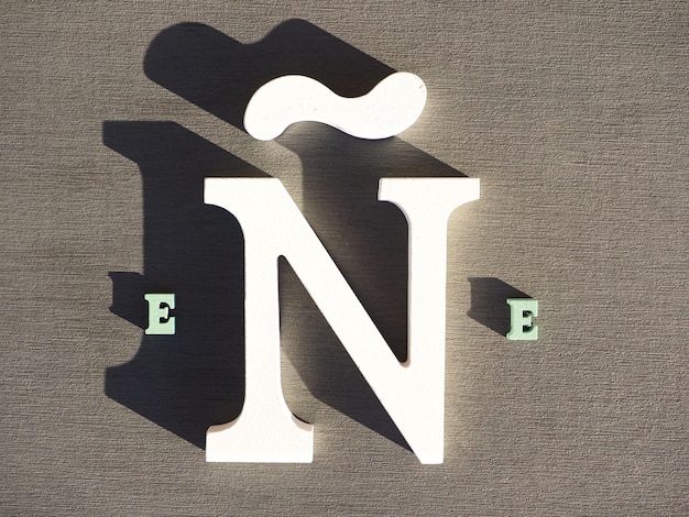 Witte houten n-letter op een grijze achtergrond Ene Spaanse taalsymbool