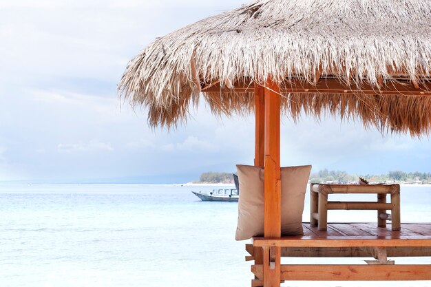 Witte houten schuilplaats met strodak tegen de zon op het strand in Bali of Thailand. Gili-eiland