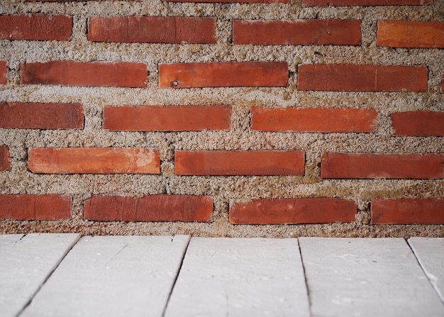 Witte houten tafel tegen bakstenen muur