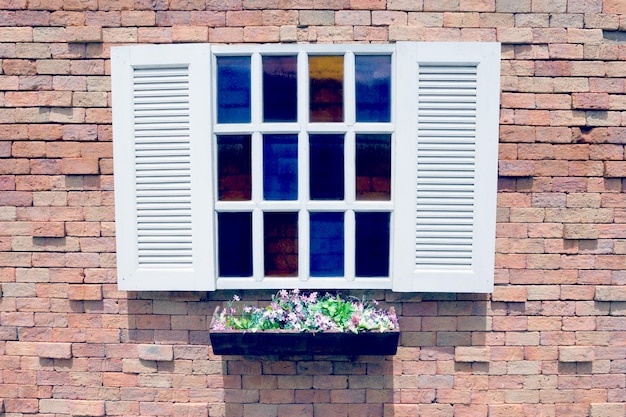 Witte houten venster en bloempot op bakstenen muur achtergrondfilter effect