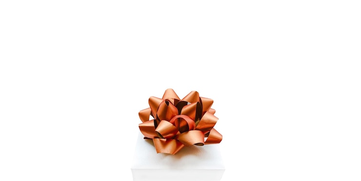 Foto witte huidige doos met grote gouden boog op witte achtergrond in feestelijk concept van bannerformaat